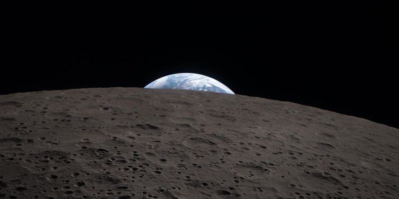 The Earth setting behind the Moon's far side, photographed by the Artemis II crew from Orion on April 6, 2026.